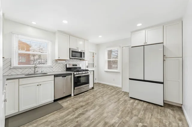 a kitchen with granite countertop stainless steel appliances a refrigerator sink and microwave