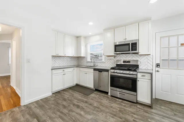 a kitchen with sink a microwave and cabinets