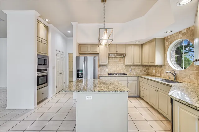 a large kitchen with cabinets and stainless steel appliances