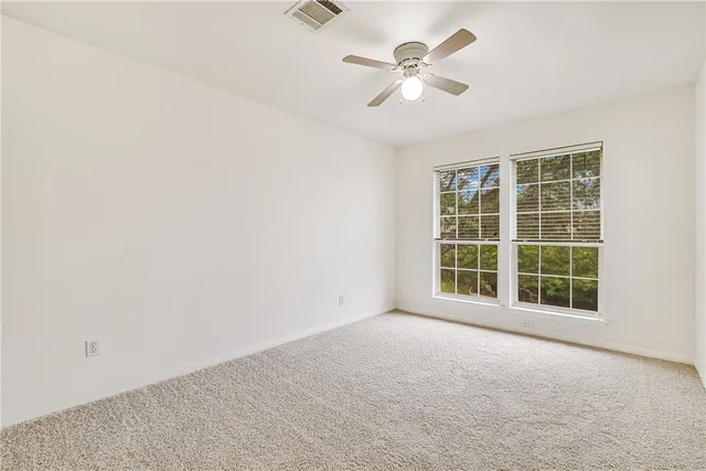 an empty room with a empty space and a ceiling fan