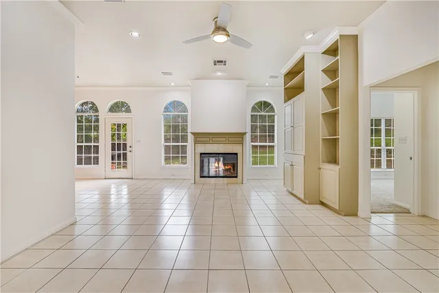 an empty room with windows and fireplace