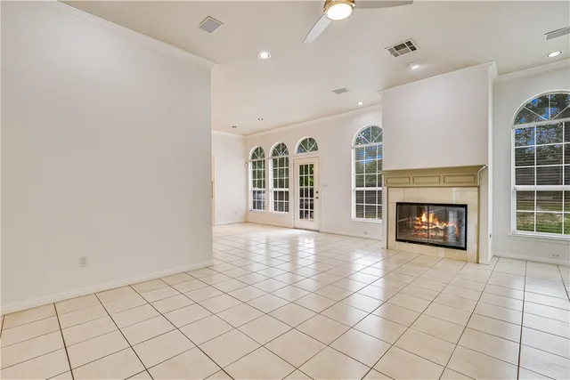 an empty room with windows and fireplace