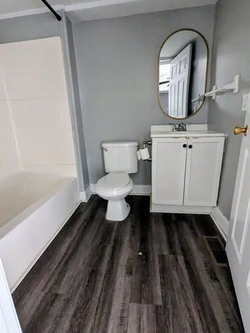 a bathroom with a toilet a sink and mirror