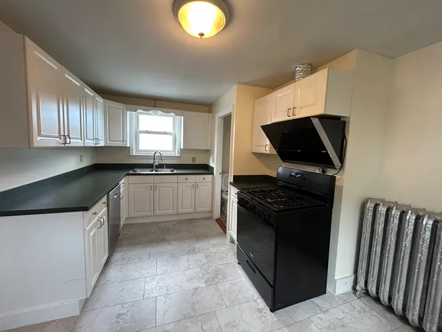 a kitchen with stainless steel appliances kitchen island granite countertop a sink and a stove