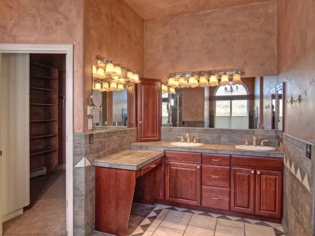 a bathroom with a granite countertop sink and a large mirror
