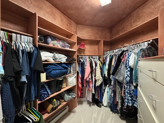 a view of walk in closet with clothes and shoes