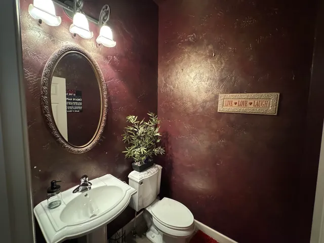 a bathroom with a toilet a sink and mirror
