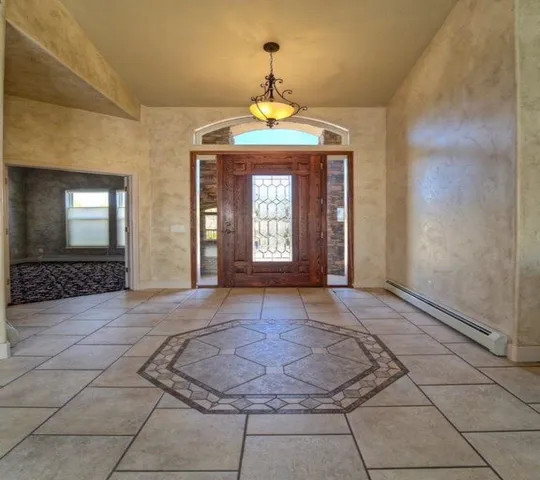 a view of a hallway with a chandelier and glass windows