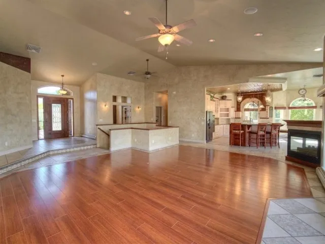 a view of a hallway with wooden floor and a kitchen