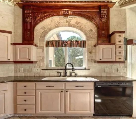 a kitchen with granite countertop a sink and a stove