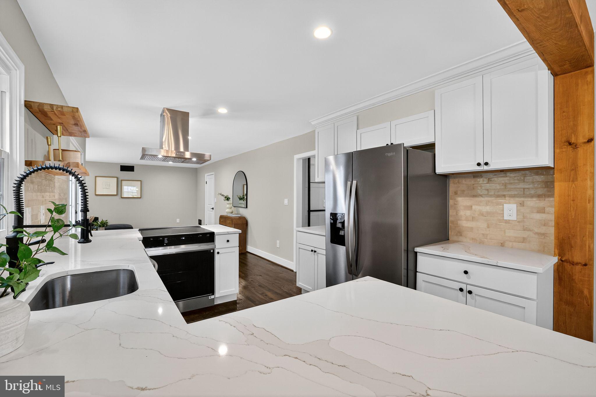 3428 Beret Lane Silver Spring, MD 20906 - Photo 9 of 33 a kitchen with stainless steel appliances kitchen island granite countertop a refrigerator a sink a stove and white cabinets with wooden floor