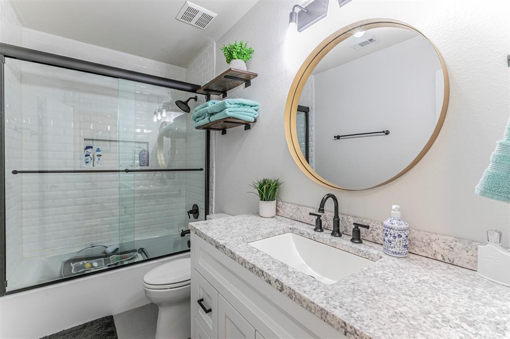 3433 Charing Cross Road Midlothian, TX 76065 - Photo 18 of 27 a bathroom with a granite countertop toilet a sink and mirror