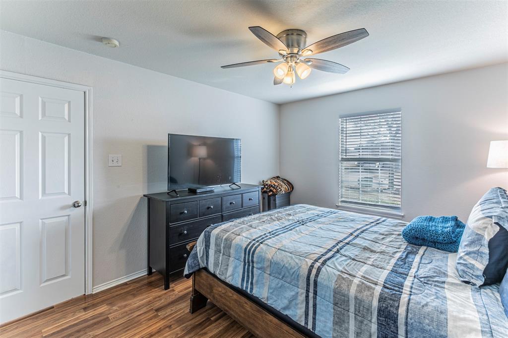 3433 Charing Cross Road Midlothian, TX 76065 - Photo 20 of 27 a bedroom with a large bed and a chandelier