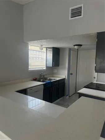 a kitchen with granite countertop a refrigerator and a sink