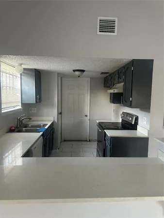 a kitchen with stainless steel appliances a sink a stove and a refrigerator