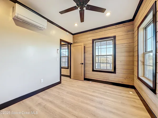a view of an empty room with a window and a ceiling fan