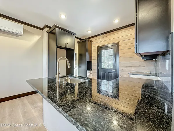 a bathroom with a granite countertop sink and a mirror