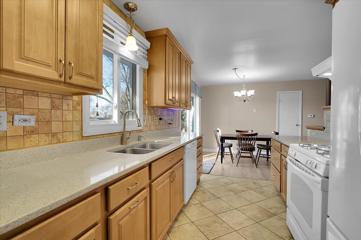 426 Thunderbird Trail Carol Stream, IL 60188 - Photo 15 of 34 a kitchen with kitchen island granite countertop a sink cabinets and stove top oven