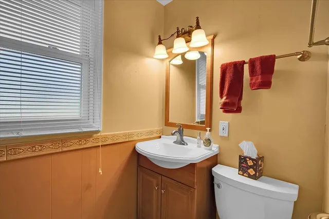 a bathroom with a sink a toilet and mirror