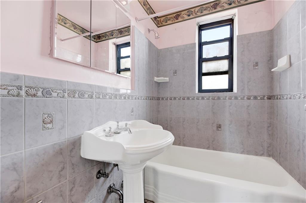 2260 Burnett Street, Unit 6K Brooklyn, NY 11229 - Photo 14 of 17 a bathroom with a sink a mirror and a bathtub
