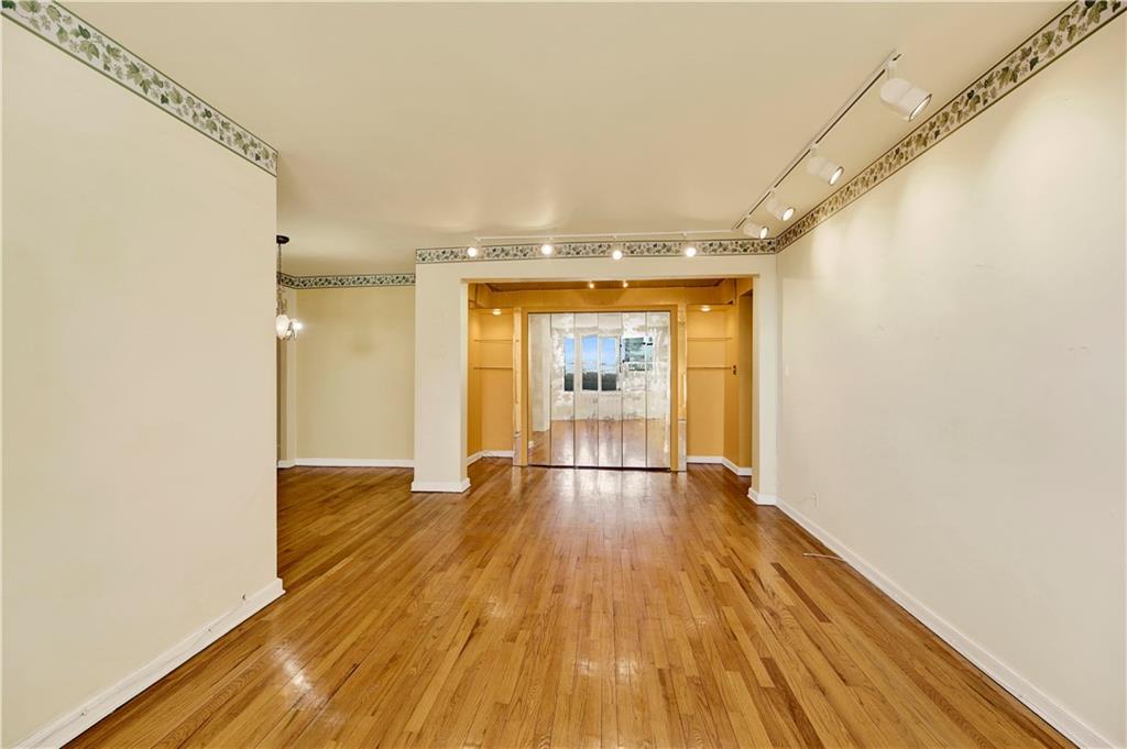 2260 Burnett Street, Unit 6K Brooklyn, NY 11229 - Photo 4 of 17 a view of an empty room with wooden floor and a window