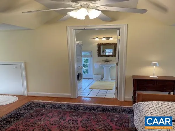 a view of a bedroom with a bed and wooden floor