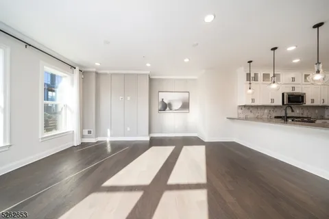 a view of a kitchen with refrigerator and wooden floor