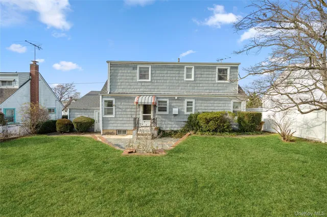 a front view of a house with a garden and yard
