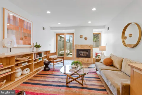 a living room with furniture a fireplace and a large window