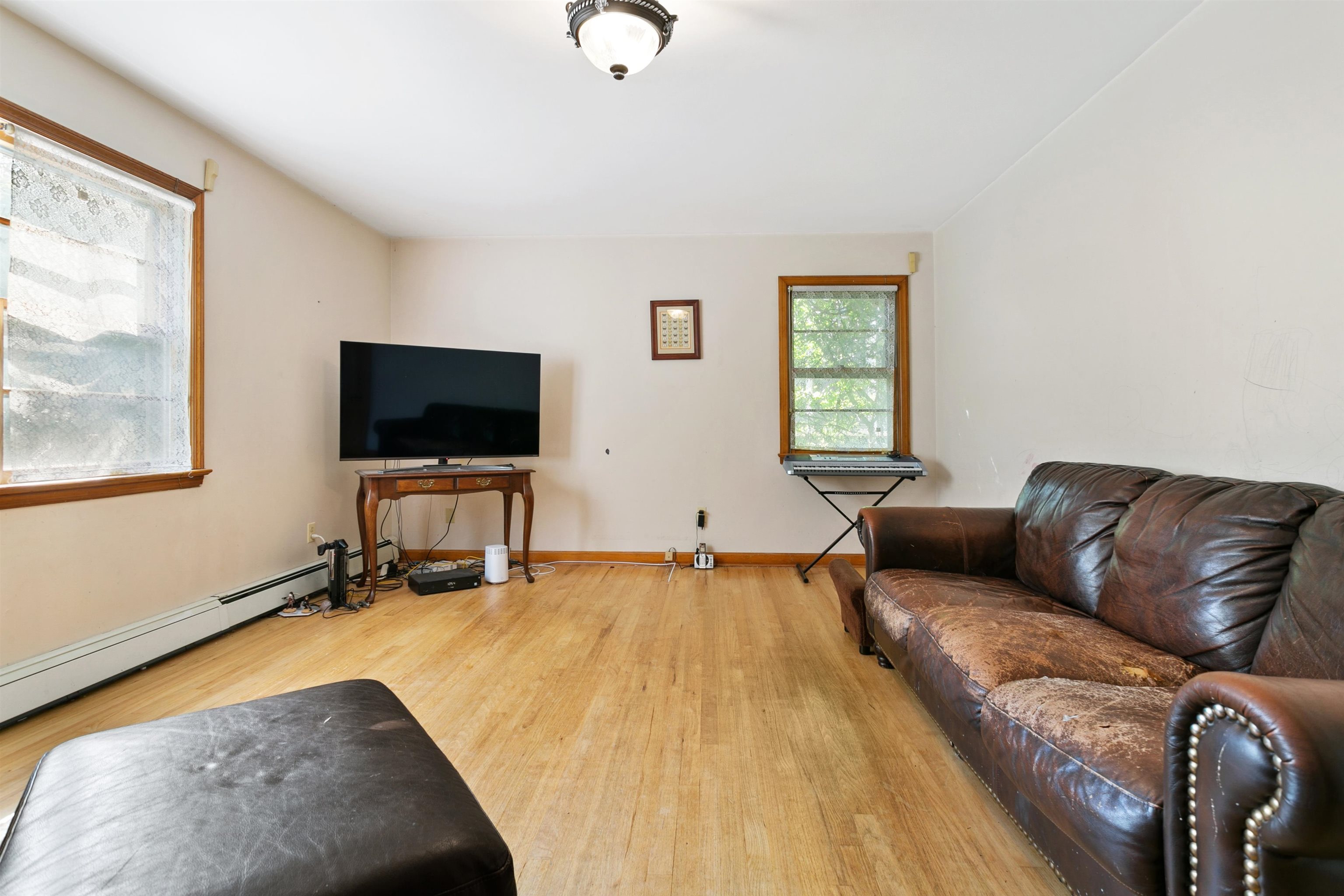 39 Raymond Avenue Rutherford, NJ 07070 - Photo 7 of 15 a living room with a bed furniture and a flat screen tv