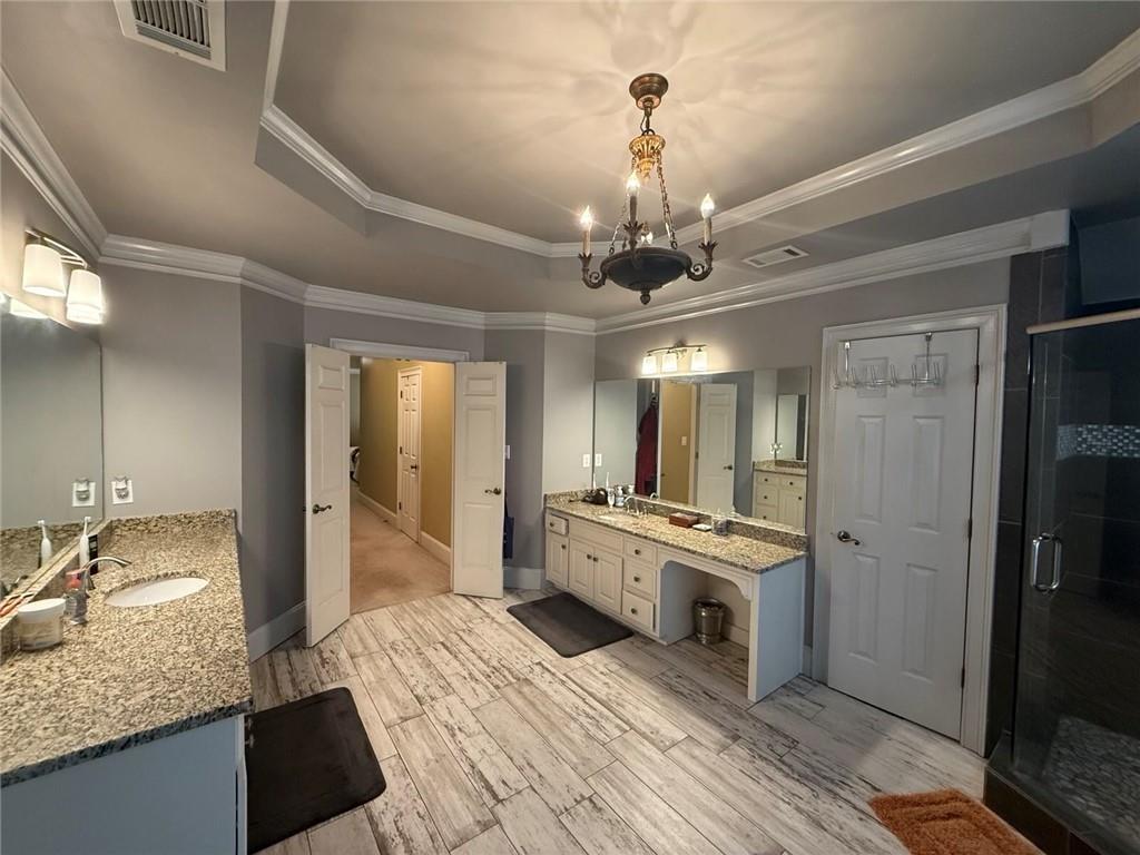 8350 Jacobs Ridge Lane Cumming, GA 30028 - Photo 28 of 68 a spacious bathroom with a granite countertop sink a large mirror and a shower