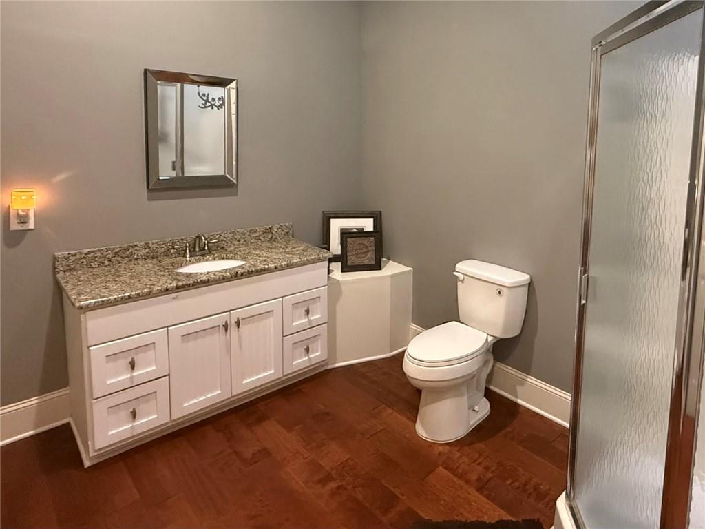 8350 Jacobs Ridge Lane Cumming, GA 30028 - Photo 48 of 68 a bathroom with a granite countertop toilet a sink and a mirror