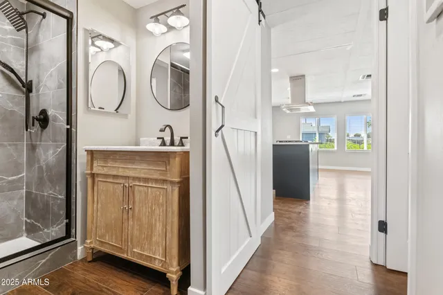a bathroom with a double vanity sink mirror and shower
