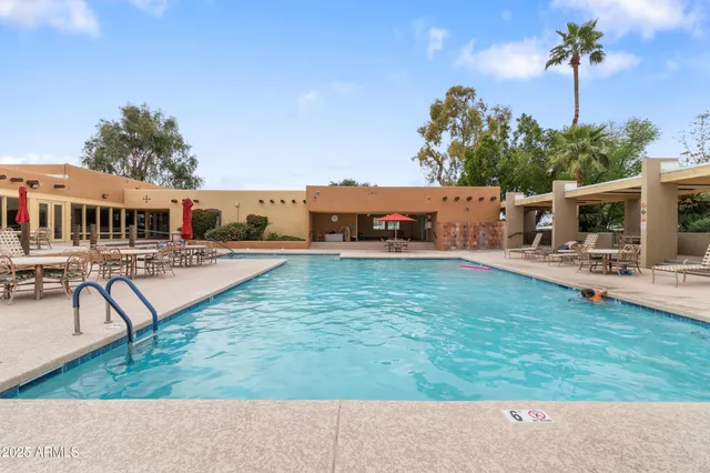 a swimming pool with outdoor seating and yard