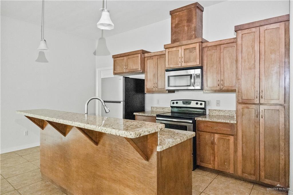 2715 Mimosa Street, Unit 2 Mission, TX 78574 - Photo 5 of 13 a kitchen with stainless steel appliances granite countertop a stove refrigerator sink and cabinets