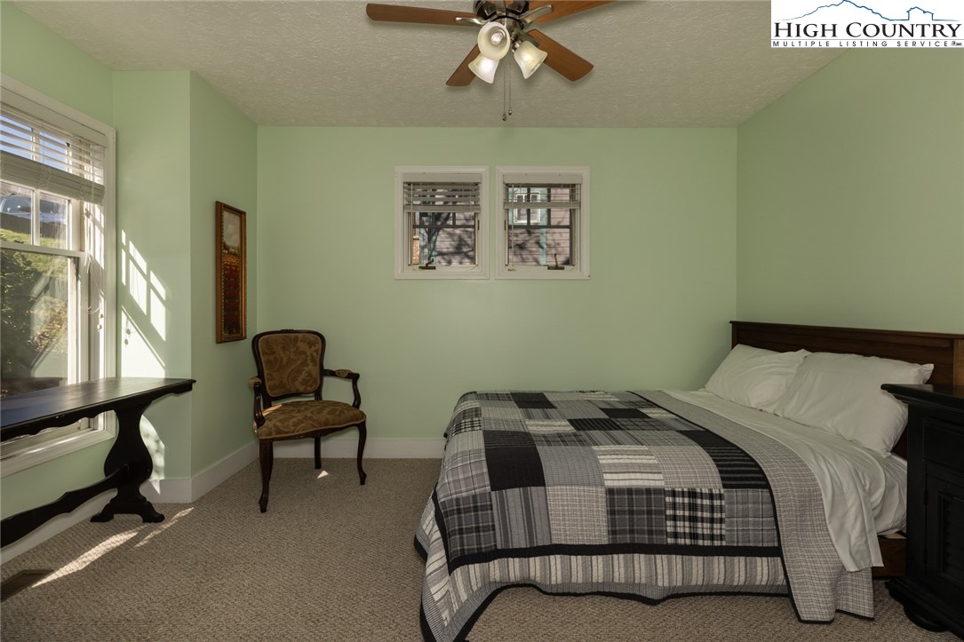446 Peaceful Haven Drive, Unit 811 Boone, NC 28607 - Photo 14 of 19 a bedroom with a bed and a chandelier