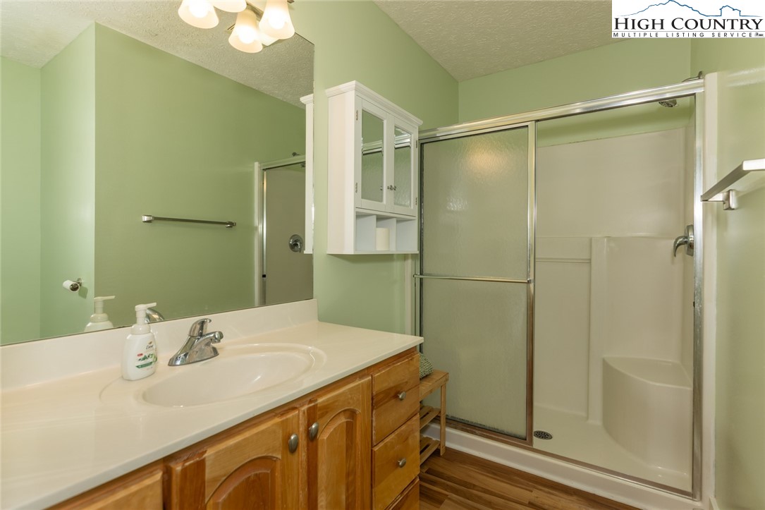 446 Peaceful Haven Drive, Unit 811 Boone, NC 28607 - Photo 17 of 19 a bathroom with a shower sink and mirror