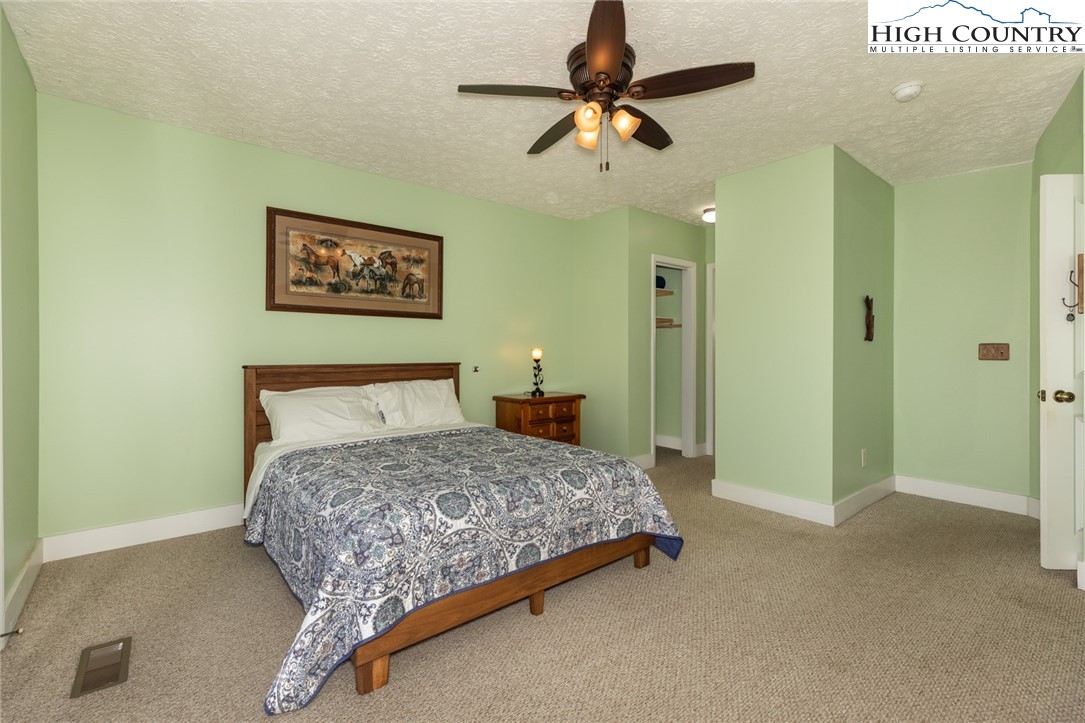 446 Peaceful Haven Drive, Unit 811 Boone, NC 28607 - Photo 19 of 19 a bedroom with a bed and a chandelier