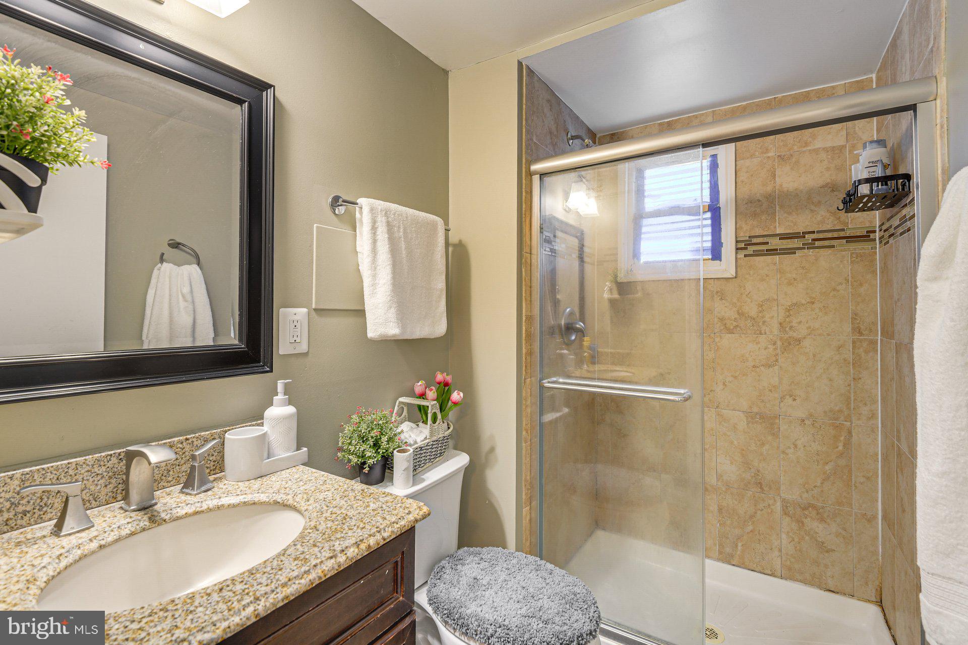 5929 Camberly Avenue Springfield, VA 22150 - Photo 15 of 24 a bathroom with a granite countertop sink toilet and shower