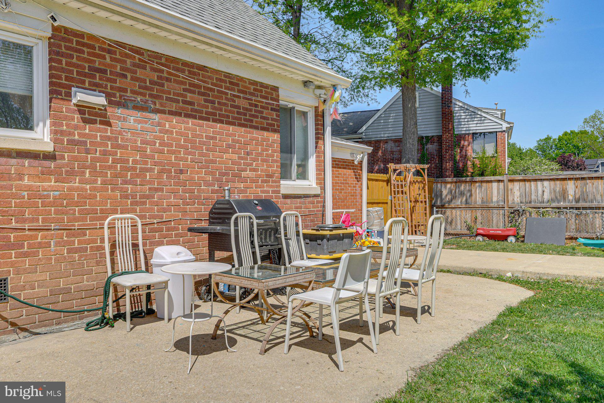 5929 Camberly Avenue Springfield, VA 22150 - Photo 19 of 24 a view of a patio with table and chairs with wooden fence and plants