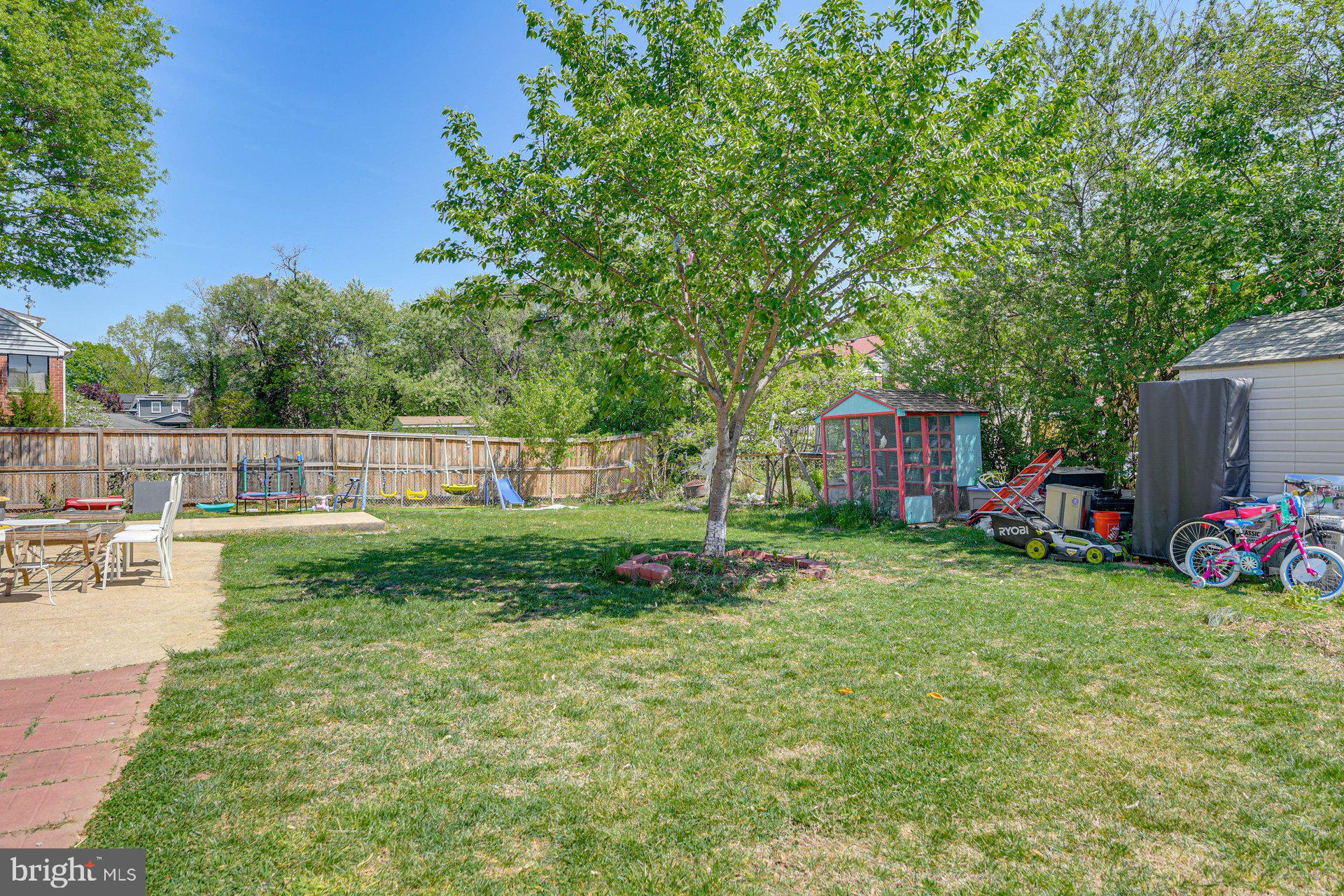 5929 Camberly Avenue Springfield, VA 22150 - Photo 22 of 24 a view of a backyard with table and chairs plants and large tree
