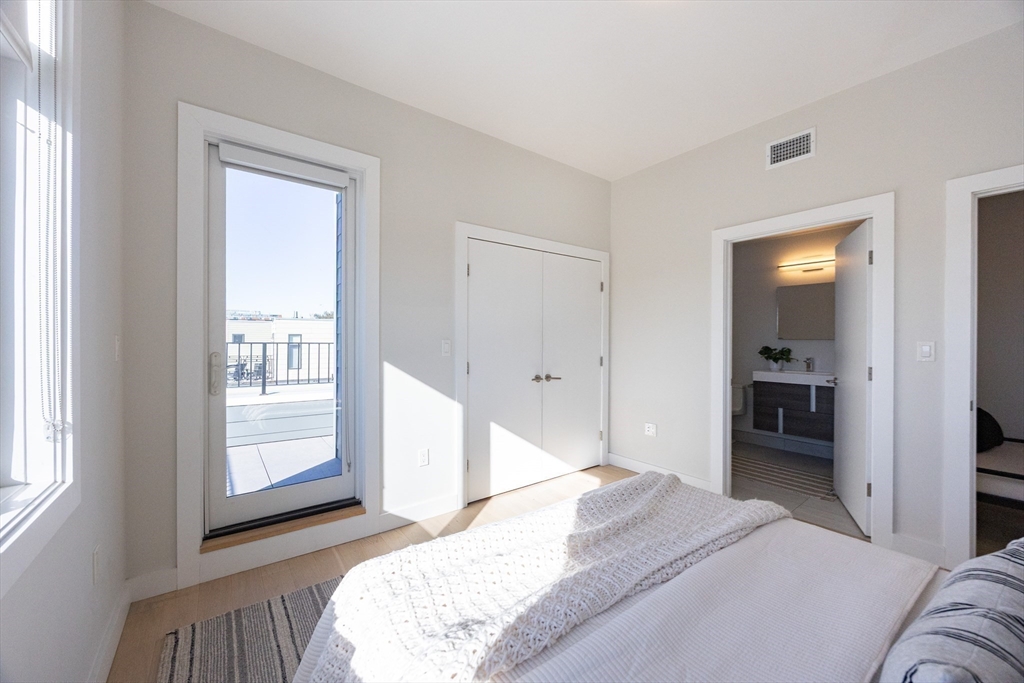1 Loring Street, Unit 3 Somerville, MA 02143 - Photo 19 of 39 a bedroom with a bed and a large mirror