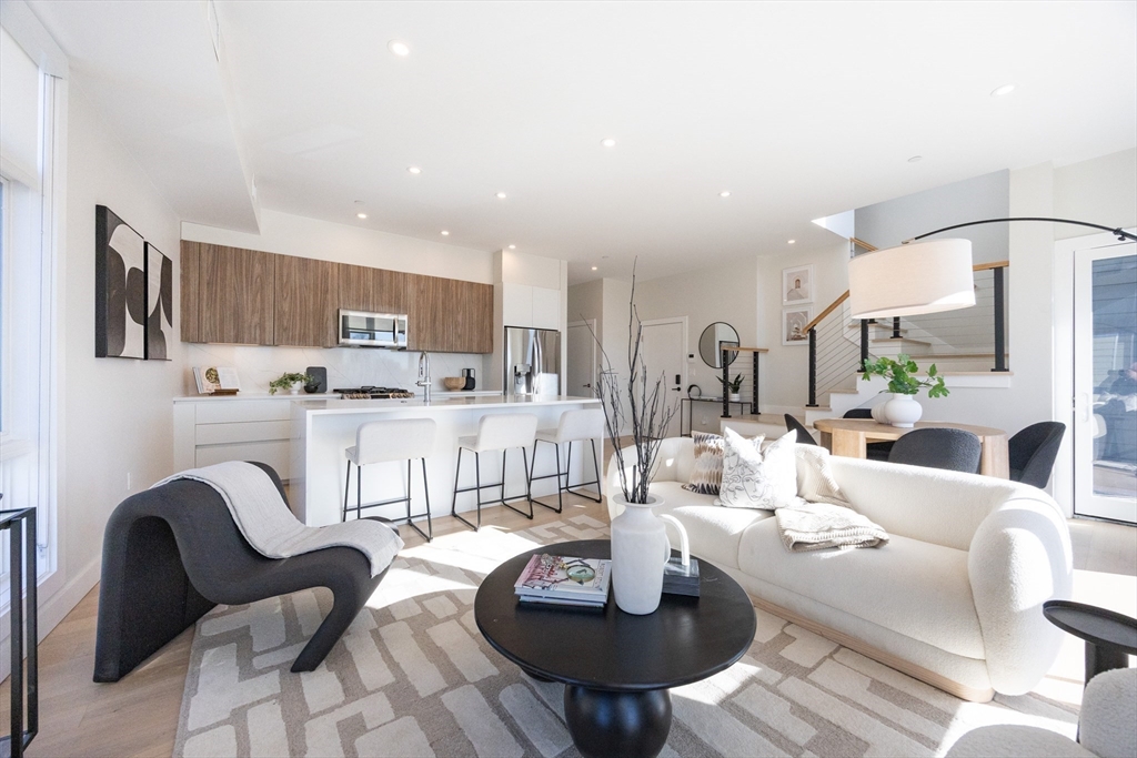 1 Loring Street, Unit 3 Somerville, MA 02143 - Photo 2 of 39 a living room with stainless steel appliances furniture a rug and a kitchen view