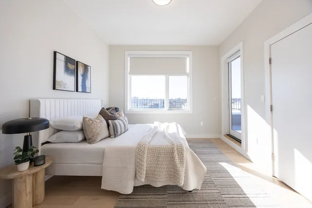 a bedroom with a bed and a large window