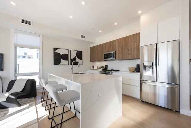 a kitchen with stainless steel appliances granite countertop a refrigerator and a stove top oven
