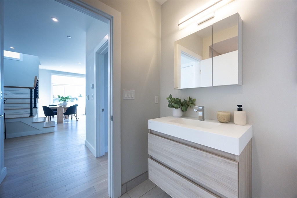 1 Loring Street, Unit 3 Somerville, MA 02143 - Photo 31 of 39 a view of a hallway that has a couch and a dining table in it