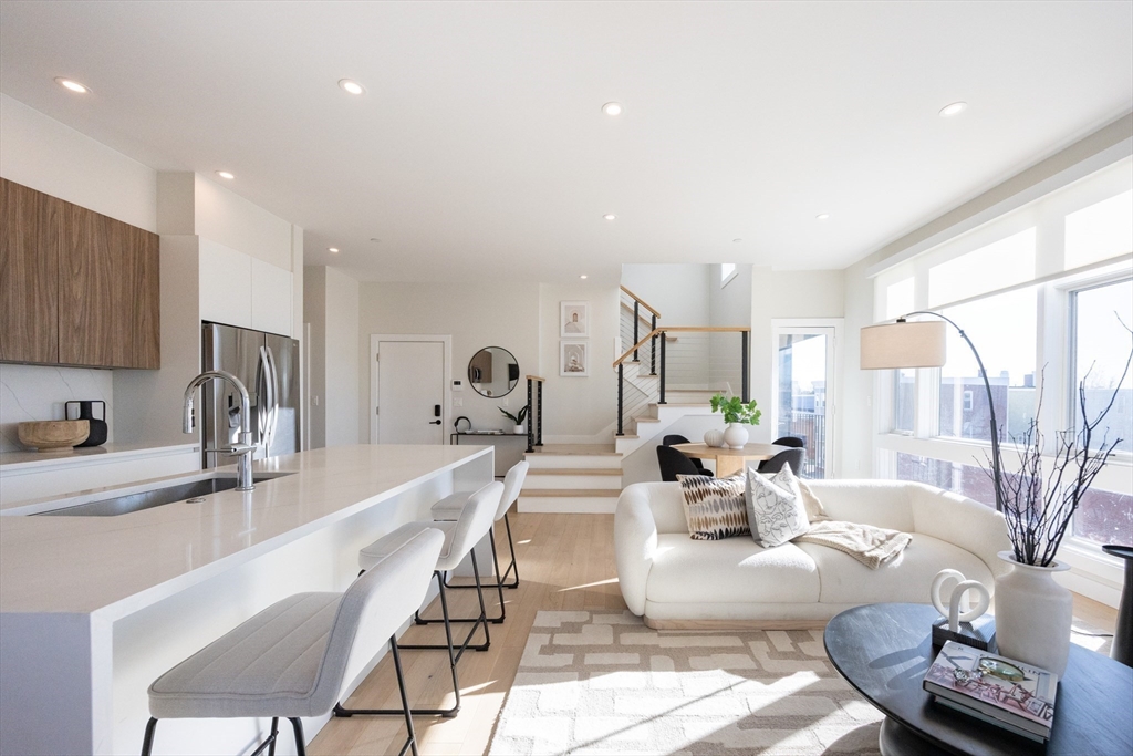 1 Loring Street, Unit 3 Somerville, MA 02143 - Photo 36 of 39 a view of a kitchen with kitchen island granite countertop a living room