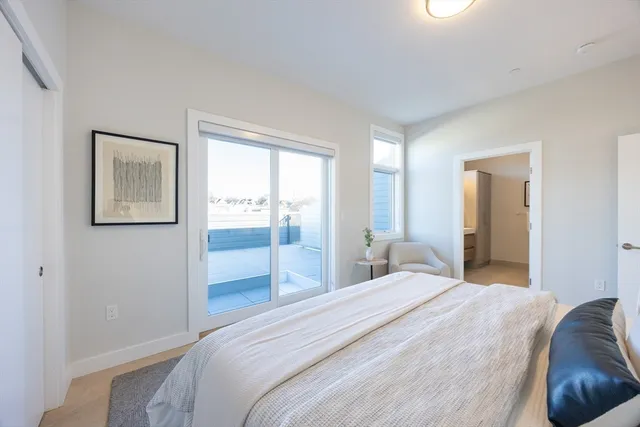 a bedroom with a bed and glass windows