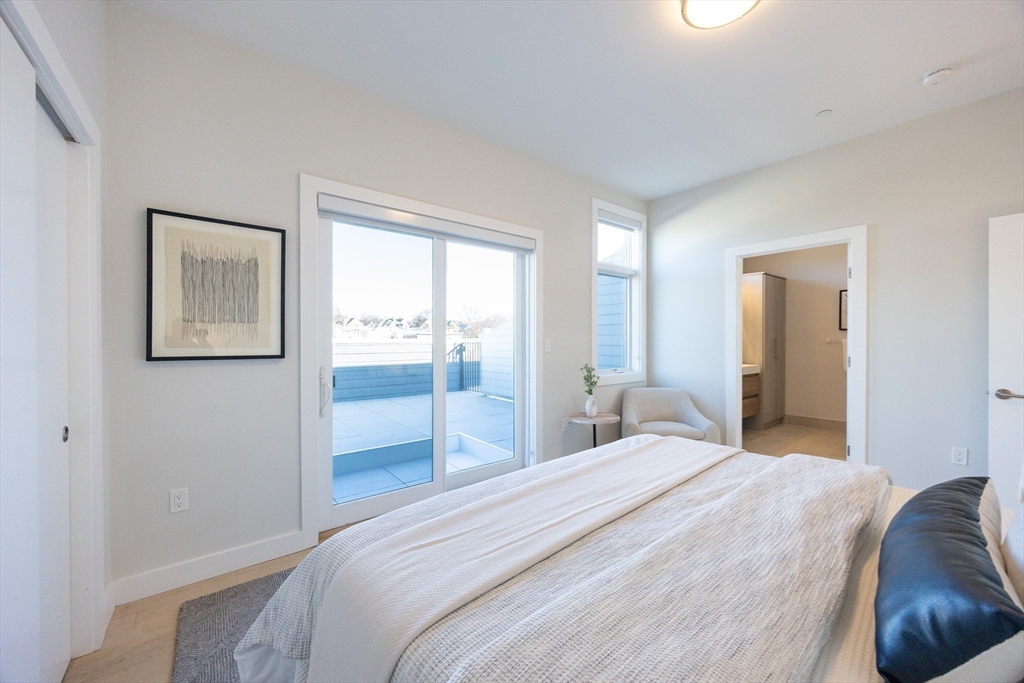 1 Loring Street, Unit 3 Somerville, MA 02143 - Photo 8 of 39 a bedroom with a bed and glass windows