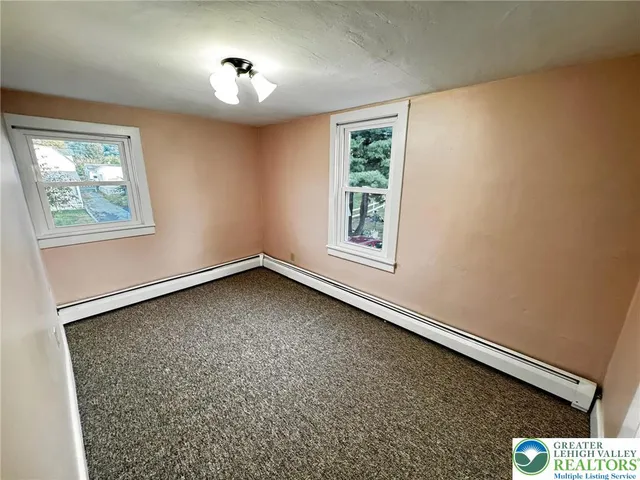 a view of a house with backyard and trees